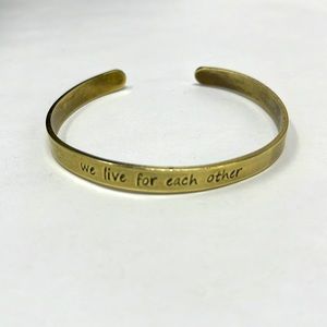 Brass cuff bracelet saying “we live for each other”